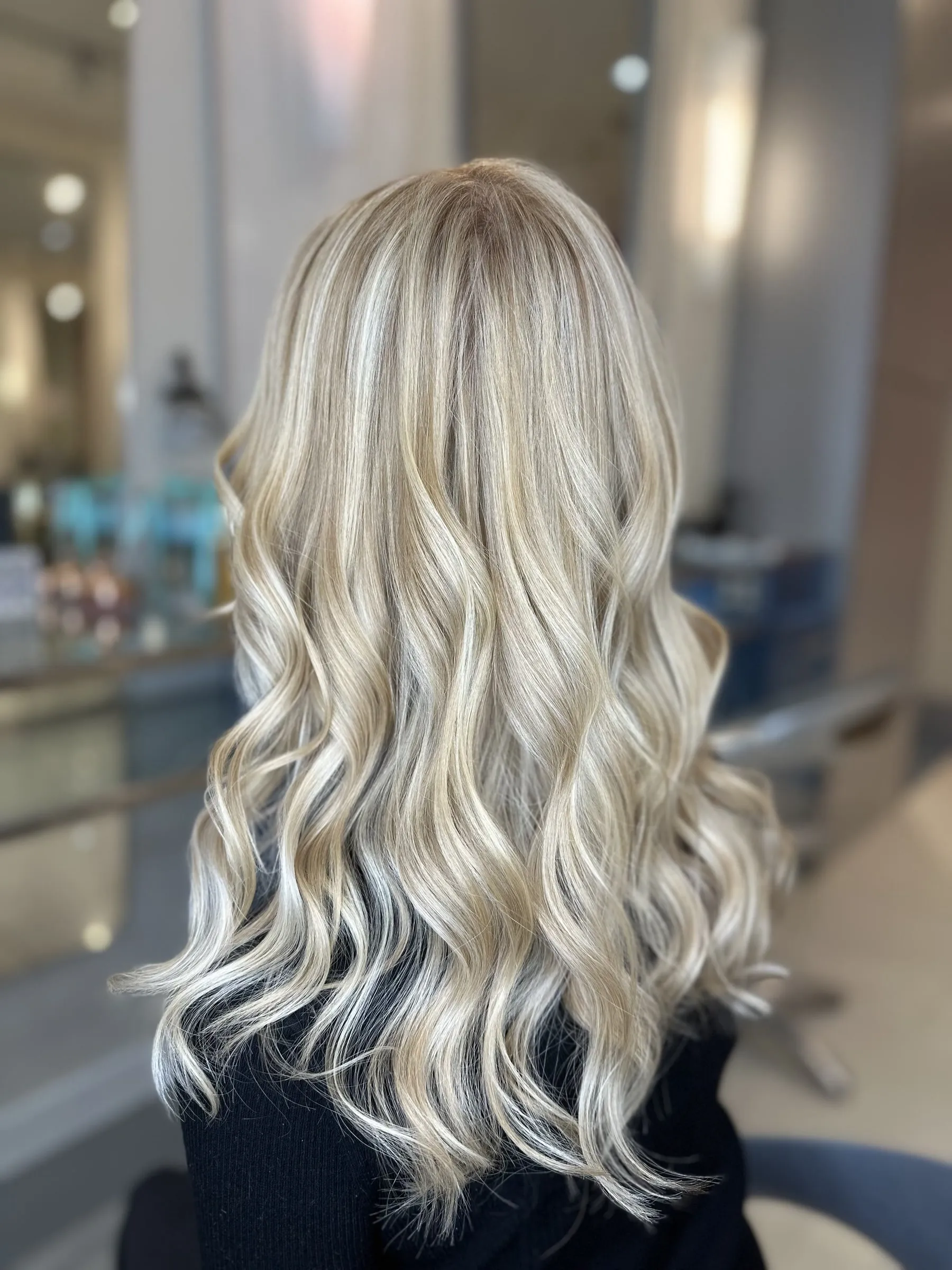 Bright blonde balayage on long soft waves by Ronak Hairstylist in Toronto