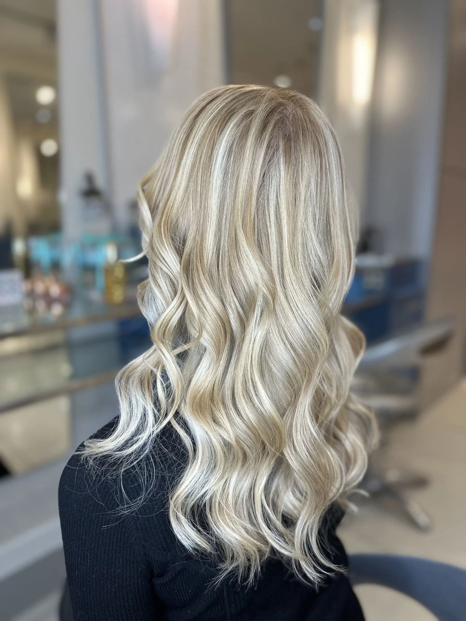 Bright blonde highlights on long waves by Ronak Hairstylist in Toronto