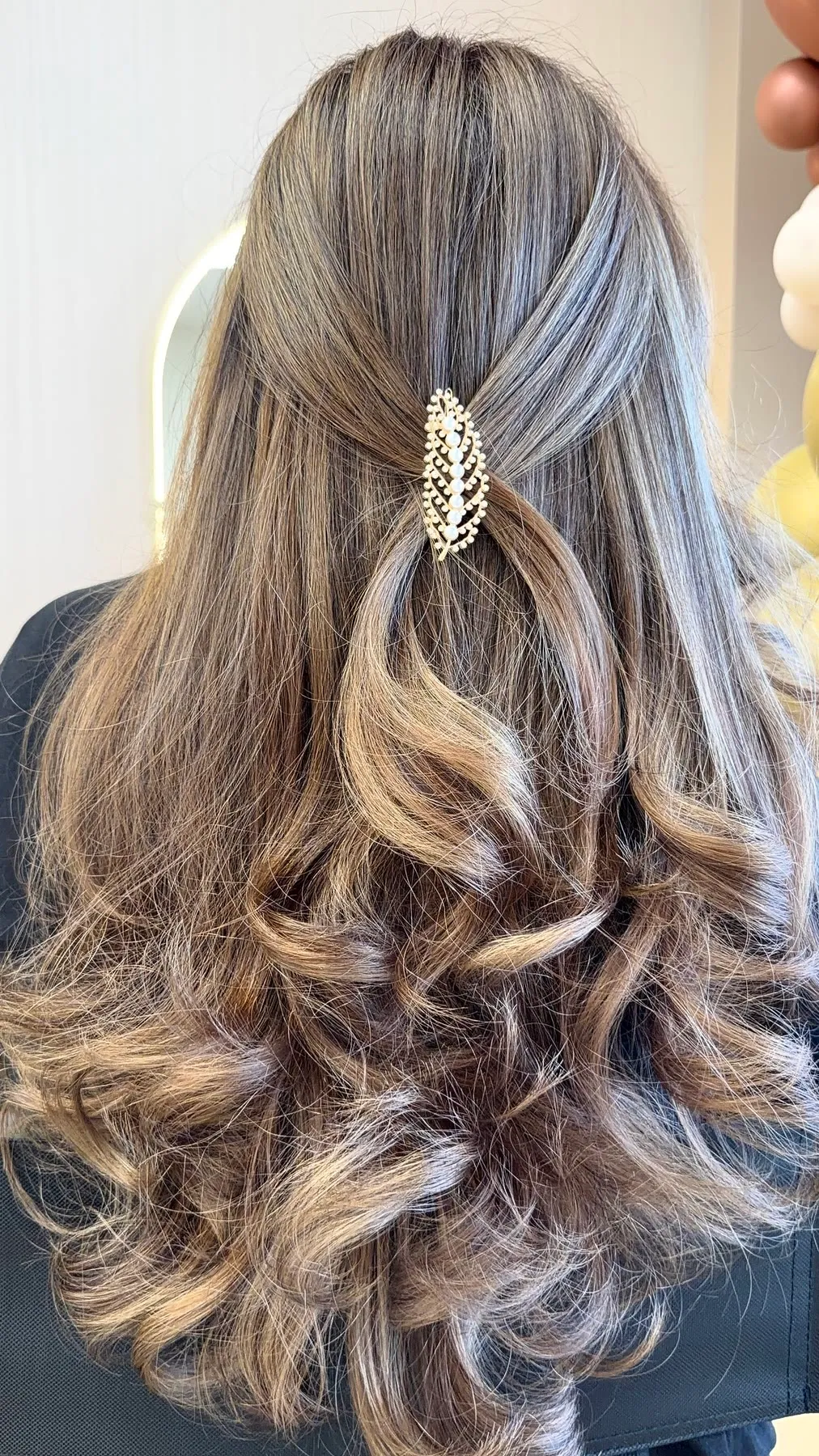 Half-up style with a pearl clip over bronde curls by Ronak Hairstylist in Toronto