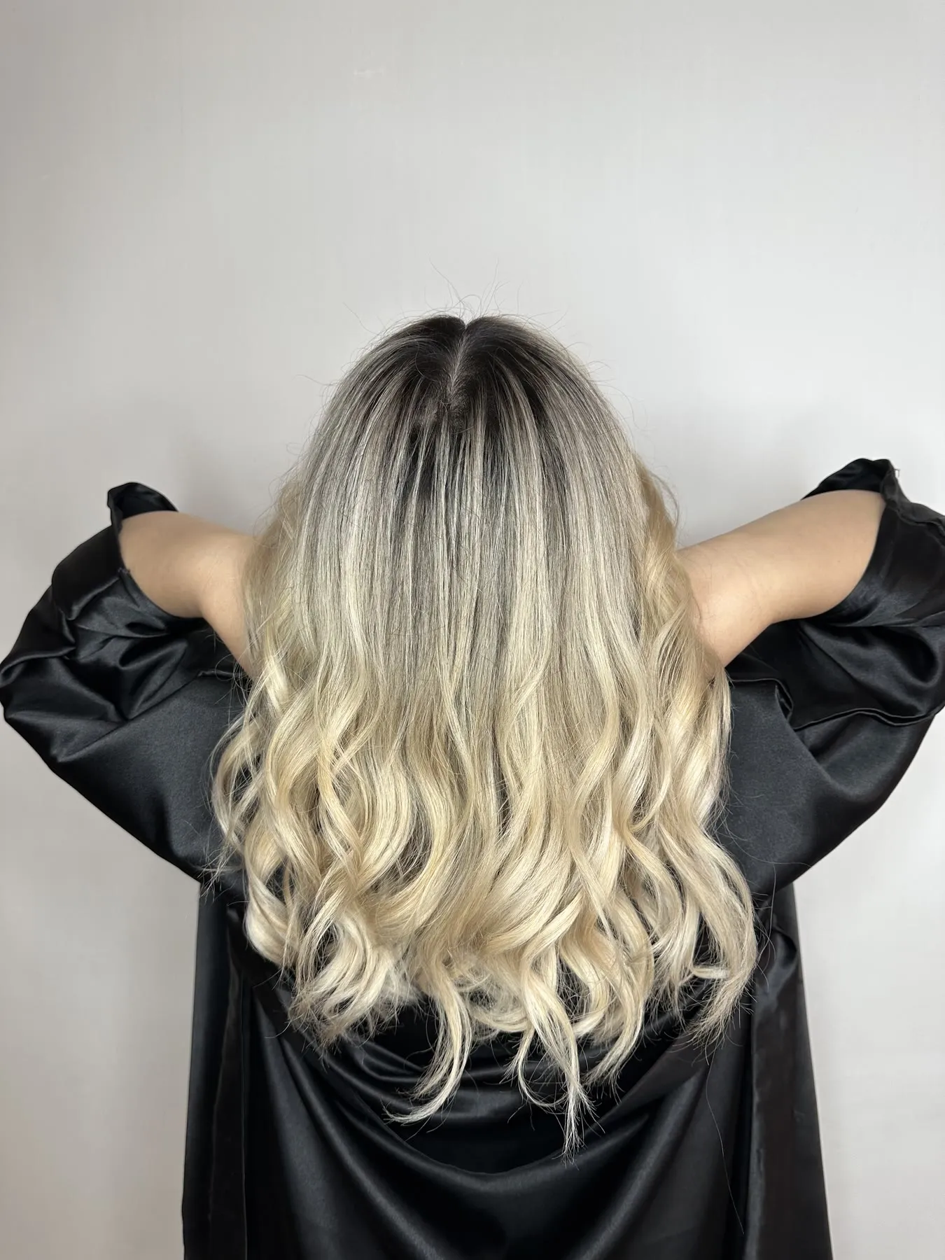 Blonde balayage with a shadow root on long waves by Ronak Hairstylist in Toronto