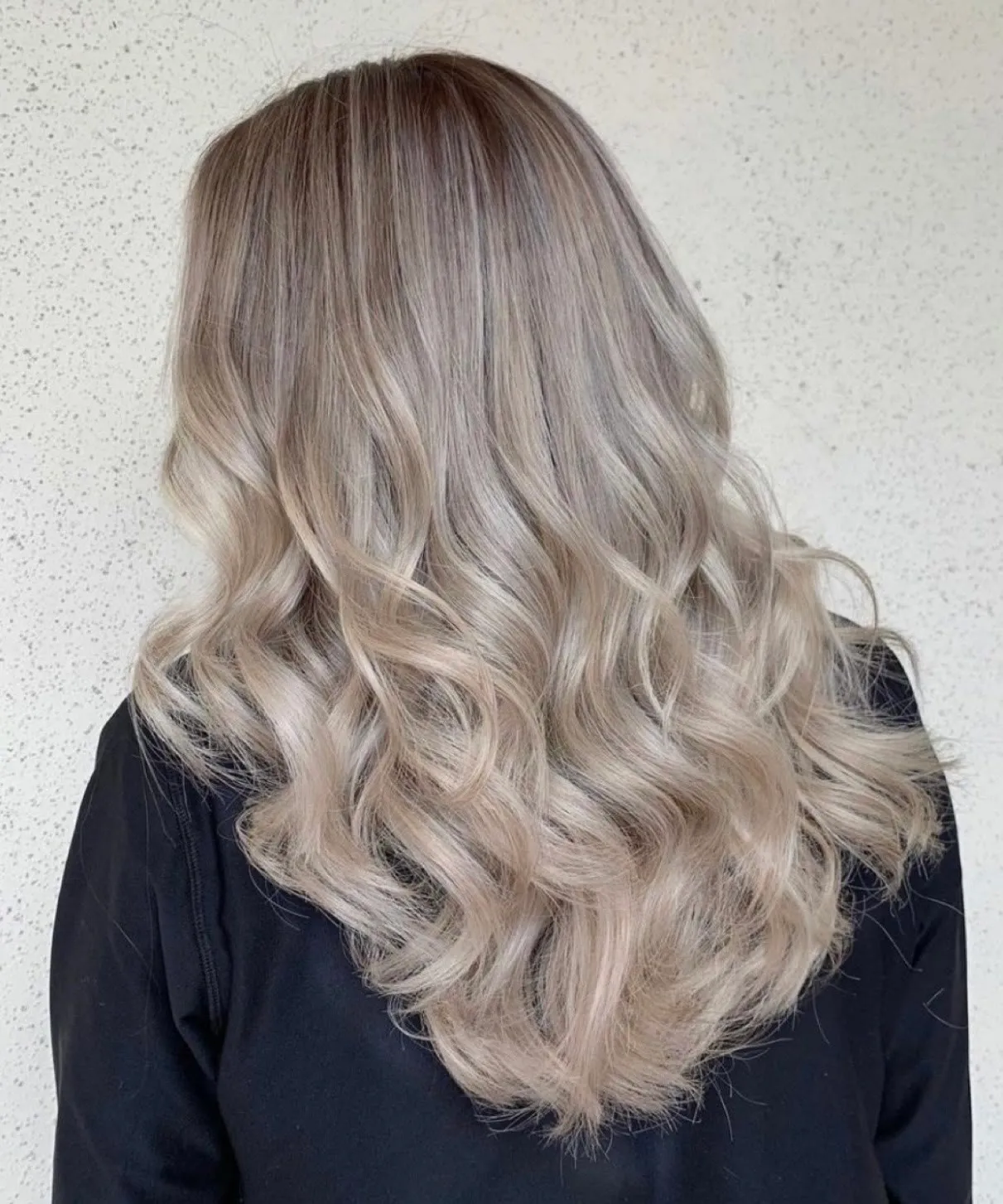 Soft ash beige blonde on long waves by Ronak Hairstylist in Toronto